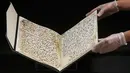 Ahli Manuskrip memperlihatkan penggalan naskah Al-Quran tertua di dunia yang ditemukan di Universitas Birmingham, Inggris, Rabu (22/7/2015). Penanggalan radiokarbon menunjukkan manuskrip itu berusia setidaknya 1.370 tahun. (REUTERS/Peter Nicholls)