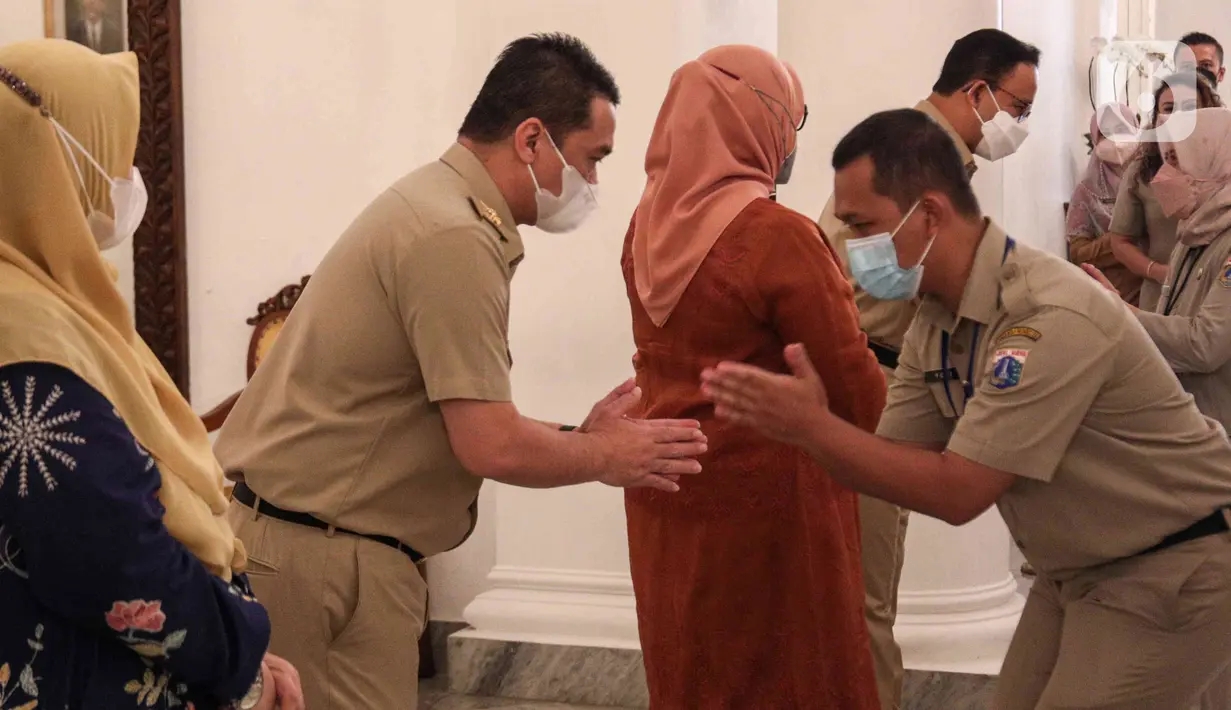 <p>Wakil Gubernur DKI Jakarta Ahmad Riza Patria didampingi istriny, Ellisa Sumarlin (kiri) bersalaman dengan pegawai Pemprov DKI saat halal bihalal di Balai Kota DKI, Jakarta, Senin (9/5/2022). Anies Baswedan menggelar halal bihalal bersama para ASN Pemprov DKI Jakarta seusai libur Lebaran 2022. (Liputan6.com/Herman Zakharia)</p>