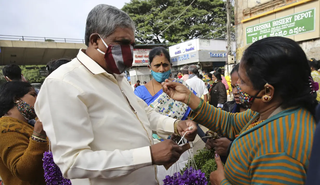 Seorang penjual bunga  berinteraksi dengan calon pembeli di pasar grosir di Bengaluru, India, Kamis (24/9/2020). Negara berpenduduk 1,3 miliar itu diperkirakan akan menjadi negara terparah pandemi COVID-19 dalam beberapa minggu, melampaui AS. (AP Photo/Aijaz Rahi)