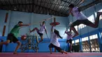 Seorang gadis menangkis serangan empat anak laki-laki yang menggunakan pedang selama berlatih Krabi Krabong di sekolah Thonburee Woratapeepalarak, Thonburi, Bangkok (8/7/2019). Krabi Krabong merupakan seni bela diri Thailand yang dipersenjatai pisau dan perisai kayu. (AFP Photo/Lillian Suwanrumpha)