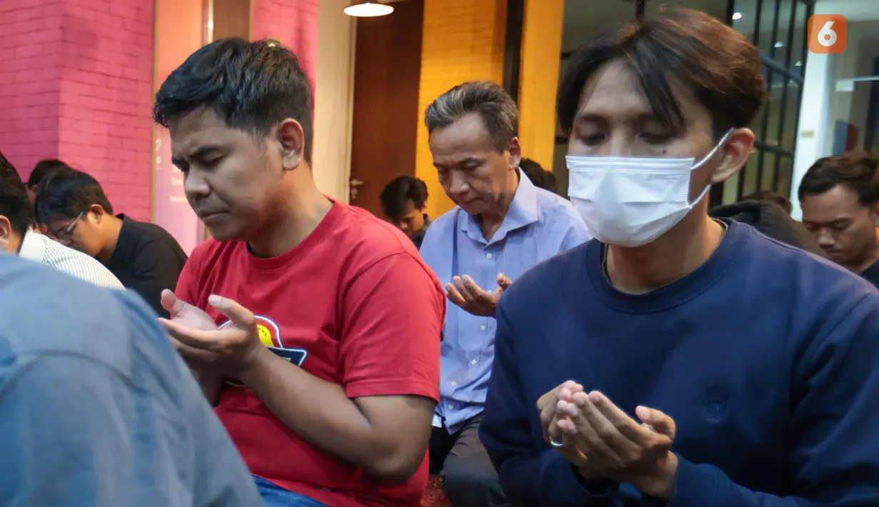 Karyawan KLY menundukkan kepala saat mengikuti doa bersama untuk Arie Basuki dan empat jurnalis lainnya yang hilang kontak saat meliput aktivitas Gunung Anak Krakatau di perairan Selat Sunda, Kamis (10/9/2026). (KLY/Budy Santoso)