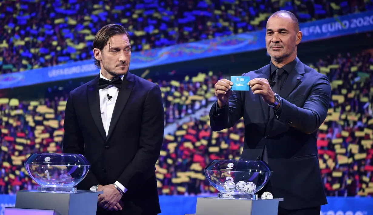 Duta Besar EURO2020 Ruud Gullit (kanan) bersama mantan pemain bola Italia Francesco Totti (kiri) saat undian final Euro 2020 di Bucharest, Rumania, 30 November 2019. Ketum PSSI Mochammad Iriawan sudah menghubungi Ruud Gullit sejak sepekan lalu untuk melatih Timnas Indonesia. (Fabrice COFFRINI/AFP)