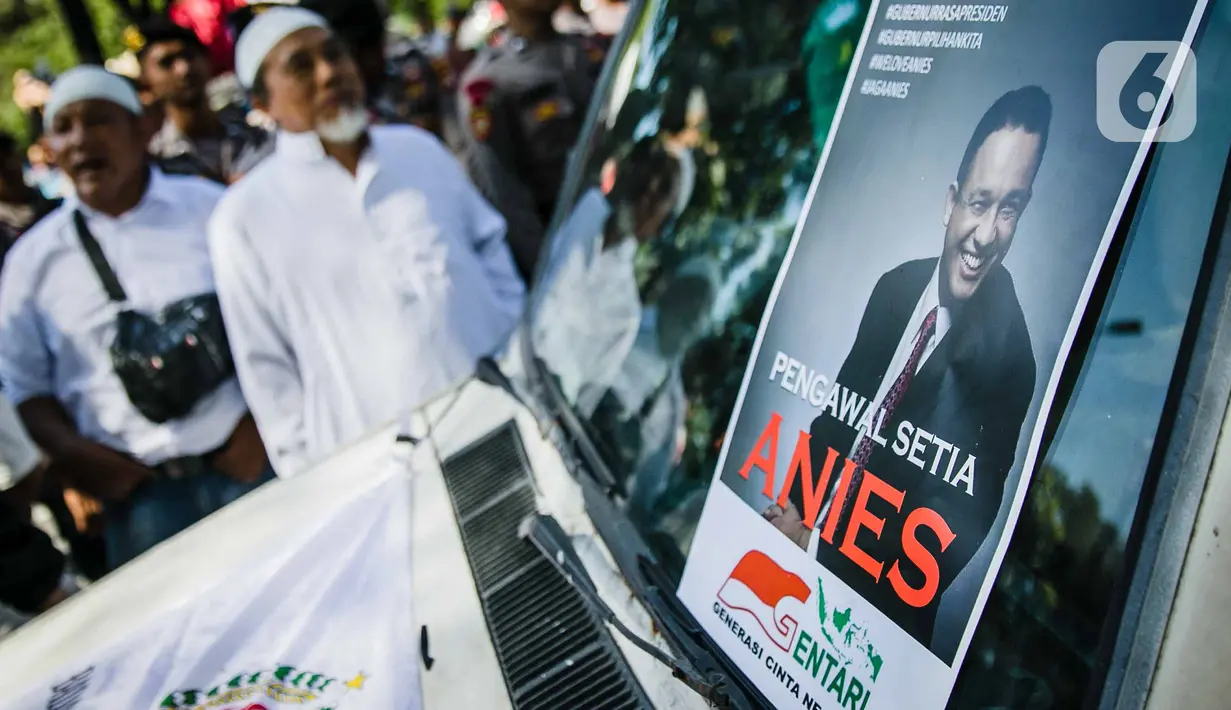 Massa Gentari (Genarasi Cinta Negeri) membawa poster dalam aksi dukungan kepada Gubernur DKI, Anies Baswedan di Balai Kota DKI Jakarta, Selasa (14/1/2020). Mereka mengawal Anies Baswedan agar menyelesaikan program kerja sebagai Gubernur DKI terkait penanganan banjir. (Liputan6.com/Faizal Fanani)
