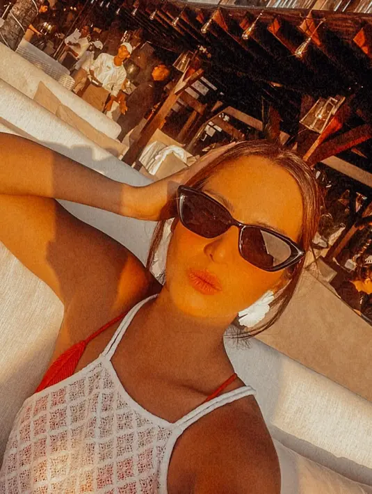 Yang kemudian di beberapa kesempatan, ia tumpuk dengan dress rajut putih bertali spageti. Nia tampak semakin menawan dengan tambahan sunglasses. [Foto: Instagram/ramadhaniabakrie]