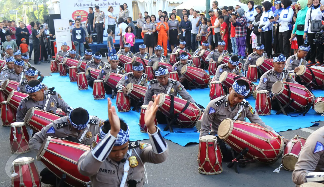 Sejumlah polisi memainkan gendang pada kegiatan car free day di Jakarta, Minggu (9/4). Dalam atraksi yang juga diikuti polisi wanita (polwan) tersebut mereka melakukan melakukan sosialisasi “Polwanku Sahabatku”. (Liputan6.com/Angga Yuniar)