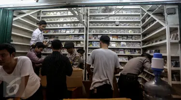 Petugas memeriksa tempat produksi VCD dan DVD bajakan di Plaza Glodok, Jakarta, Rabu (24/6). Penggerebekan dilakukan karena pabrik sekaligus tempat penjualan DVD terbesar di DKI Jakarta itu masih beroperasi selama Ramadan. (Liputan6.com/Faizal Fanani)