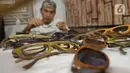 Perajin Yuyud Wahyudi (39) menyelesaikan pembuatan frame kacamata dari limbah kayu bekas di Pondok Benda, Pamulang, Tangsel, Kamis (8/10/2019). Sebelum pandemi, Yuyud menerima banyak pesanan seperti dari Italia, Norwegia, Prancis dan Jerman, namun kini turun hingga 75 persen. (merdeka.com/Dwi Narwok