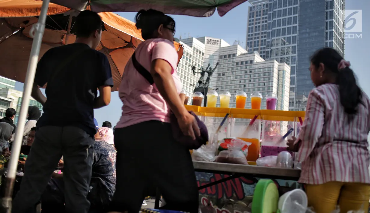 Pedagang kaki lima (PKL) berjualan saat pelaksanaan CFD di kawasan Bundaran HI, Jakarta, Minggu (5/5/2019). Kurangnya pengawasan petugas menyebabkan banyak PKL berjualan tidak pada tempat yang telah di sediakan Pemprov DKI sehingga mengganggu aktivitas warga berolahraga. (Liputan6.com/Faizal Fanani)