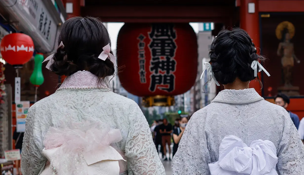 Dua wanita mengenakan yukata, pakaian musim panas tradisional Jepang mengunjungi kuil Buddha Sensoji di distrik Asakusa Tokyo (12/8/2021). Menurut urutan tingkat formalitas, yukata adalah kimono nonformal yang dipakai pria dan wanita pada kesempatan santai di musim panas. (AFP/David Gannon)