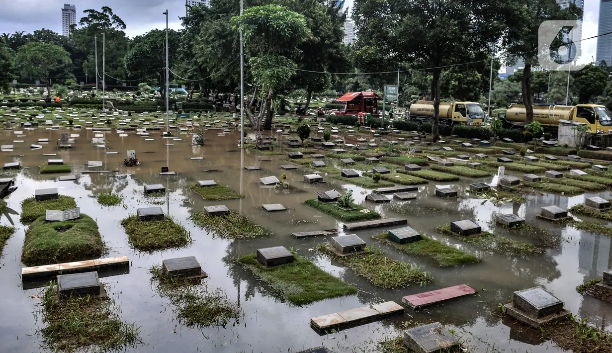 Kondisi Taman Pemakaman Umum (TPU) Karet Bivak, Jakarta, saat terendam banjir, Minggu (7/2/2021). Hujan deras yang mengguyur sejak Minggu dinihari menyebabkan tiga blok di kompleks pemakaman TPU Karet Bivak terendam banjir hingga ketinggian mencapai 30 sentimeter. (merdeka.com/Iqbal Nugroho)