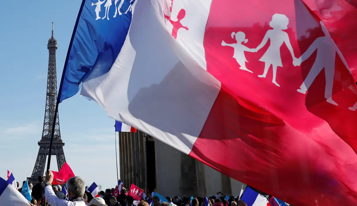 Pengunjuk rasa memadati sekitaran menara Eiffel di Paris, Prancis, Minggu (16/10). Mereka membawa bendera yang bertuliskan "La Manif Pour Tous" dan menentang pernikahan sejenis. (Reuters/ Benoit Tessier)