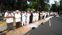 Massa pendukung pasangan capres-cawapres Prabowo Subianto dan Sandiaga Uno melakukan salat asar di Jalan Medan Merdeka Barat, Jakarta, Kamis (27/6/2019). Aksi tersebut dilakukan jelang putusan perselisihan hasil pemilihan umum (PHPU) Pilpres 2019 di Gedung MK. (merdeka.com/Arie Basuki)