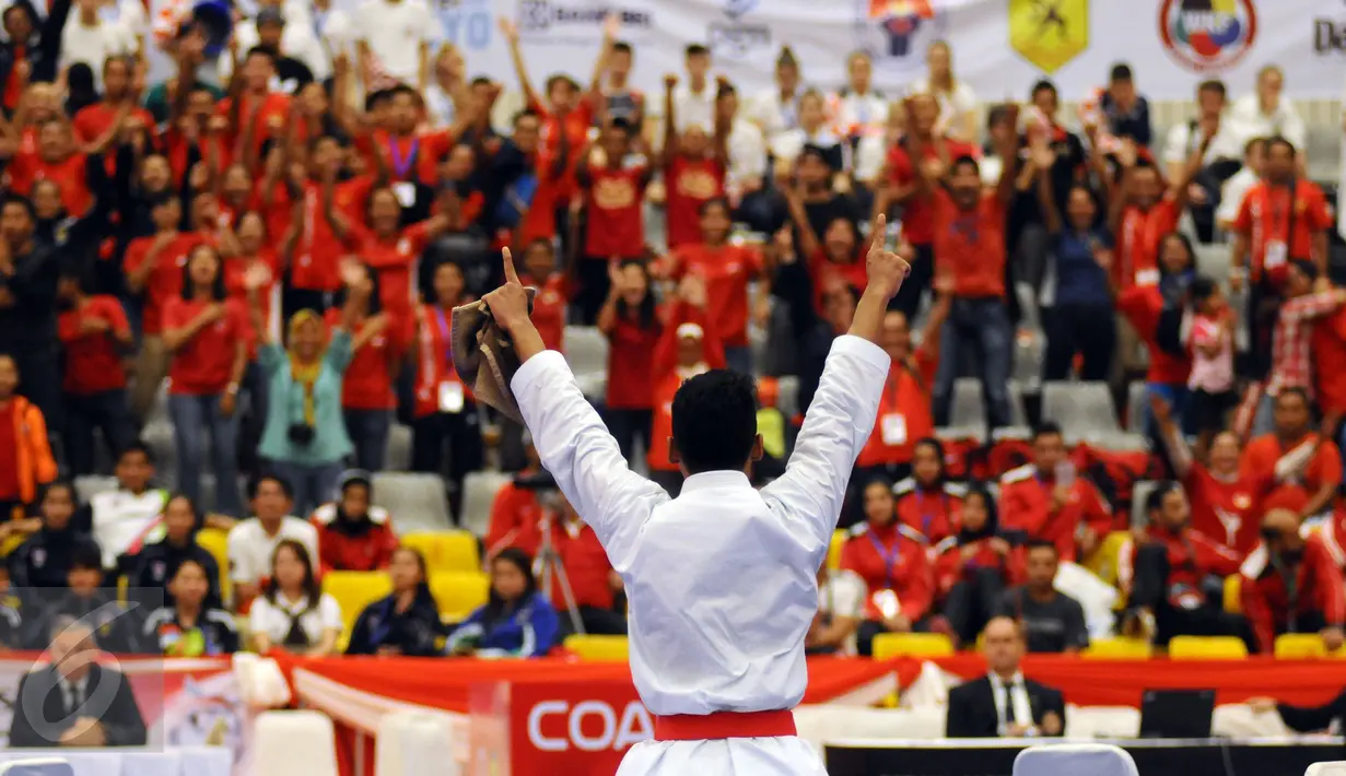 Ahmad Zigi Zaresta mengangkat tangan usai menang di final Junior Kata Male di WKF World Junior, Cadet and U-21 Championship 2015 di ICE Serpong, Banten, Kamis (12/11/2015). Zigi menyumbang emas pertama bagi Indonesia. (Liputan6.com/Helmi Fithriansyah)