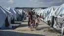 Migran berjalan setelah hujan badai di kamp pengungsi Kara Tepe, di timur laut pulau Lesbos, Aegean, Yunani (14/10/2020).  Sekitar 7.600 pengungsi dan migran telah menetap di kota tenda baru setelah kebakaran berturut-turut pada tanggal 14 September. (AP Photo/Panagiotis Balaskas)
