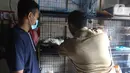Petugas memeriksa kesehatan kucing di Pasar Barito, Jakarta, Senin (28/3/2022). Penyemprotan disinfektan, pemeriksaan kesehatan hewan dan vaksinasi rabies gratis untuk mengantisipasi penyebaran penyakit di pasar hewan tersebut. (Liputan6.com/Herman Zakharia)
