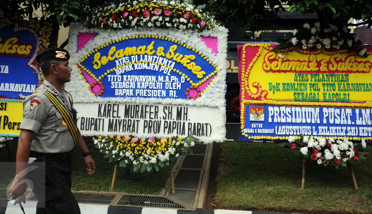 Petugas piket mengecek karangan bunga ucapan selamat atas dilantiknya Komjen Pol Tito Karnavian, Mabes Polri, Jakarta, Rabu (13/7). Tito Karnavian akan dilantik menjadi Kapolri di Istana Negara oleh Presiden Jokowi. (Liputan6.com/Helmi Fithriansyah)