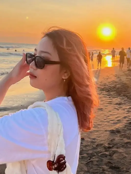 Melengkapi tampilannya dengan kacamata hitam bentuk oval, serta aksesori anting-anting minimalisnya. Dan kalung berliontin minimalis.  [@camilliazr]