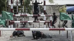 Dua kadet Palestina melewati rintangan kawat berduri saat berlatih fisik dengan militer Hamas, Brigade Ezzedin al-Qassam, di Kota Gaza (20/7/2019). Sejumlah pemuda Palestina direkrut Hamas untuk menjadi bagian anggotanya. (AFP Photo/Mahmud Hams)
