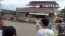 Penduduk melihat bangunan yang runtuh setelah gempa melanda Padada, provinsi Davao del Sur, Filipina selatan (15/12/2019). Gempa tersebut menyebabkan bangunan tiga lantai runtuh dan membuat warga panik bergegas keluar dari pusat perbelanjaan, rumah dan bangunan lain. (AP Photo/John Angelo Jomao-as)