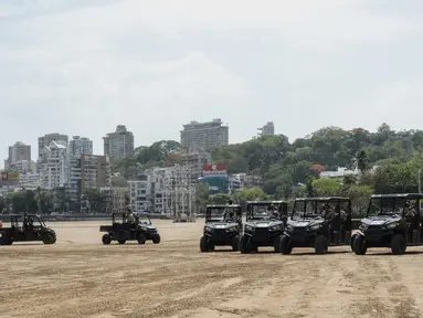 Personel polisi duduk di kendaraan segala medan (ATV) yang digunakan untuk berpatroli di pantai selama peluncurannya di Mumbai, India, Senin (7/6/2021). ATV tersebut akan digunakan untuk berpatroli di pantai-pantai di Mumbai. (Sujit Jaiswal / AFP)