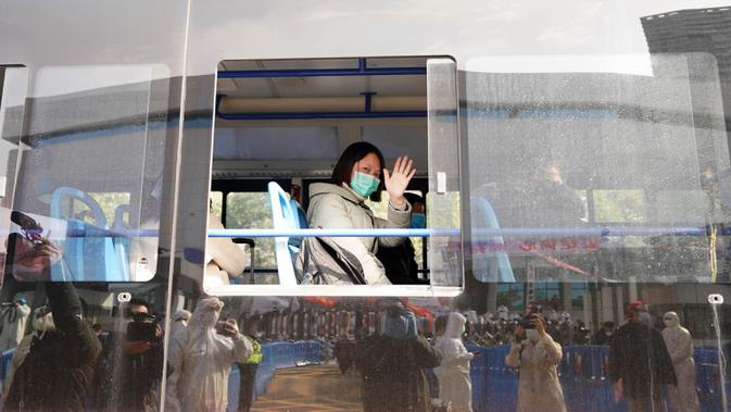 Pasien virus corona yang pulih melambaikan tangan kepada pekerja medis ketika meninggalkan rumah sakit sementara Wuchang di Wuhan, Hubei, China (10/3/2020). Kelompok terakhir yang terdiri dari 49 pasien meninggalkan rumah sakit pada Selasa (10/3) pukul 15.30 waktu setempat. (Xinhua/Wang Yuguo)