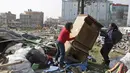 Warga membawa barang yang masih bisa terpakai di tempat pengungsian korban gempa bumi di Chuchepati, Kathmandu, Nepal, Selasa (14/3). Pemerintah Nepal terpaksa menggusur kamp ini karena sudah berdiri selama dua tahun. (AP Photo)