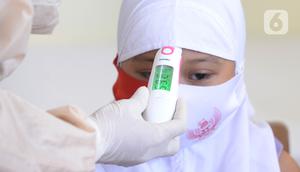 Siswa kelas I diukur suhu tubuhnya sebelum melakukan imunisasi campak saat pelaksanaan Bulan Imunisasi Anak Sekolah (BIAS) di SDN Serua 3, Ciputat, Tangsel, Selasa (1/9/2020). Kegiatan itu untuk memberikan kekebalan terhadap siswa dari penyakit campak, difteri dan tetanus. (merdeka.com/Dwi Narwoko)