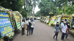 Warga berjalan di sekitar tempat persemayaman Ani Yudhoyono di Puri Cikeas, Bogor, Jawa Barat, Minggu (2/6/2019). Ani Yudhoyono akan dimakamkan di TMP Kalibata pada pukul 15.00 WIB.(Liputan6.com/Immanuel Antonius)
