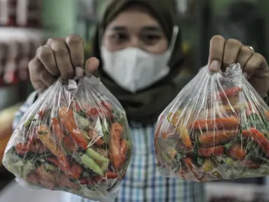 Pekerja memperlihatkan paket cabai rawit dalam Pasar Cabai Murah di Pasar Mitra Tani Klender, Duren Sawit, Jakarta, Rabu (10/3/2021). Dalam rangka menekan harga cabai di pasar, Kementan menggelar Pasar Cabai Murah di 34 lokasi Jakarta, Bogor dan Bekasi mulai 8-20 Maret. (merdeka.com/Iqbal S Nugroho)