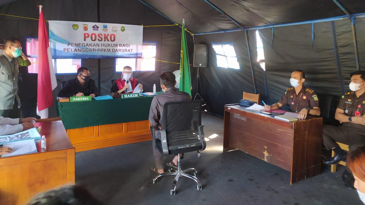 Salah satu pelanggar PPKM Darurat tengah mengikuti jalannya sidang Tipiring di tenda Posko penegakan hukum PPKM Darurat di bilangan Simpang Lima, Garut, Jawa Barat.