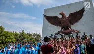 Sejumlah siswa berfoto bersama di depan Monumen Pancasila Sakti, Lubang Buaya, Jakarta, Minggu (1/10). Bertepatan dengan hari Kesaktian Pancasila, sejumlah pelajar mengadakan napak tilas ke monumen Kesaktian Pancasila. (Liputan6.com/Faizal Fanani)
