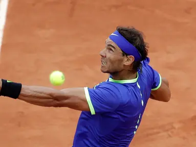 Petenis Spanyol, Rafael Nadal mengembalikan bola ke arah lawannya petenis Prancis, Benoit Paire pada babak pertama Prancis Terbuka  di Stade Roland Garros, Senin (29/5). Nadal mengalahkan tuan rumah dengan skor 6-1, 6-4, 6-1. (AP Photo/Petr David Josek)