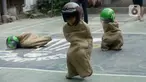 Sejumlah peserta beradu cepat dalam lomba balap karung helm di Kelurahan Benda Baru, Pamulang, Tangerang Selatan, Senin (17/8/2020). Lomba balap karung helm tersebut diselenggarakan untuk memeriahkan peringatan HUT ke-75 Kemerdekaan RI. (merdeka.com/Dwi Narwoko)