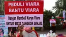 Seorang warga melakukan Aksi Peduli Viara untuk biaya cuci darah dan cangkok ginjal di kawasan Bundaran HI, Jakarta, Minggu (10/09). Aksi dengan menjual buku dan boneka kesayangan untuk biaya pengobatan. (Liputan6.com/Fery Pradolo)