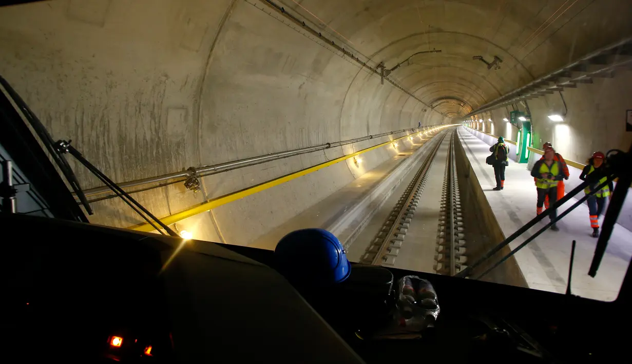 Jurnalis berdiri di atas platform terowongan NEAT Gotthard di Erstfeld, Pegunungan Alpen, Swiss (10/3). Terowongan ini memiliki panjang 57 km yang terdiri dari dua lajur paralel. (REUTERS/Arnd Wiegmann)