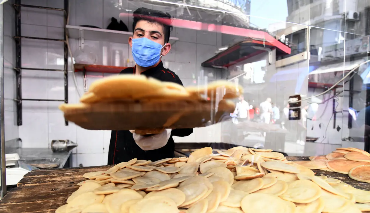 Seorang pedagang Suriah membuat "Qatayef", penganan manis tradisional yang biasa disajikan saat bulan suci Ramadan di Damaskus, Suriah, (18/5/2020). (Xinhua/Ammar Safarjalani)