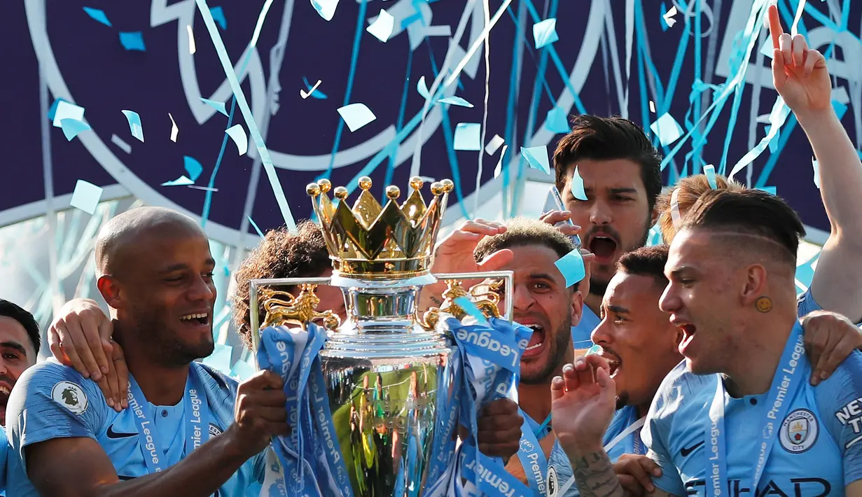 Pemain Manchester City Vincent Kompany (kiri) mengangkat trofi Liga Inggris usai mengalahkan Brighton di Stadion AMEX, Brighton, Inggris, Minggu (12/5). The Citizens menjadi yang terbaik di musim 2018-2019 usai memenangi duel sengit dengan Liverpool hingga pekan terakhir. (AP Photo/Frank Augstein)