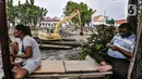 Aktivitas warga di dekat kendaraan alat berat saat pengerukan lumpur Kali Pasar Baru, Jakarta, Minggu (23/5/2021). Pengerukan lumpur Kali Pasar Baru yang merupakan aliran Kali Ciliwung itu guna mencegah pendangkalan serta mengantisipasi banjir di musim penghujan. (merdeka.com/Iqbal S Nugroho)