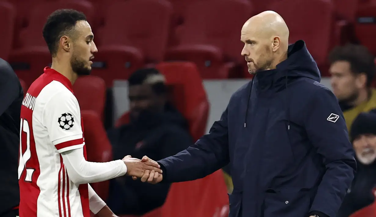 Pelatih Ajax, Erik Ten Hag (kanan) menyalami pemainnya, Noussair Mazraoui usai laga lanjutan Liga Champions 2020/21 Grup D melawan FC Midtjylland di Johan Cruijff Stadium, Amsterdam, Kamis (26/11/2020). Ajax menang 3-1 atas FC Midtjylland. (AFP/Maurice Van Steen/ANP)