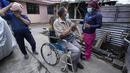 Seorang pria di kursi roda menyingsingkan lengan bajunya untuk vaksin COVID-19 di Quito, Ekuador, 26 Januari 2022. Brigade campuran dari pemerintah kota dan Kementerian Kesehatan mengunjungi lingkungan miskin untuk mendeteksi kasus COVID-19 dan melakukan vaksinasi. (AP Photo/Dolores Ochoa)