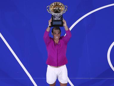 Rafael Nadal dari Spanyol mengangkat trofi usai mengalahkan Daniil Medvedev dari Rusia dalam pertandingan final tunggal putra Tenis Australia Open 2022 di Melbourne, Minggu (31/1/2022). Nadal menang lewat pertarungan lima set dengan skor 2-6, 6-7 (5-7), 6-4, 6-4, dan 7-5. (AP Photo/Tertius Pickard)