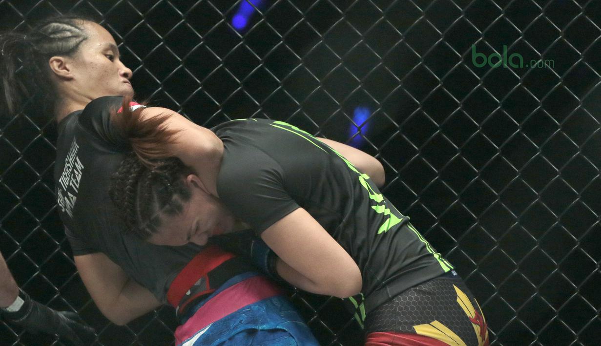 Priscilla (kiri) berusaha menahan petarung asal Filipina, Rome Trinidad pada ajang One Championship 2018 di Jakarta Convention Center, Sabtu (12/5/2018). Priscilla menang padan ronde pertama. (Bola.com/Nick Hanoatubun)
