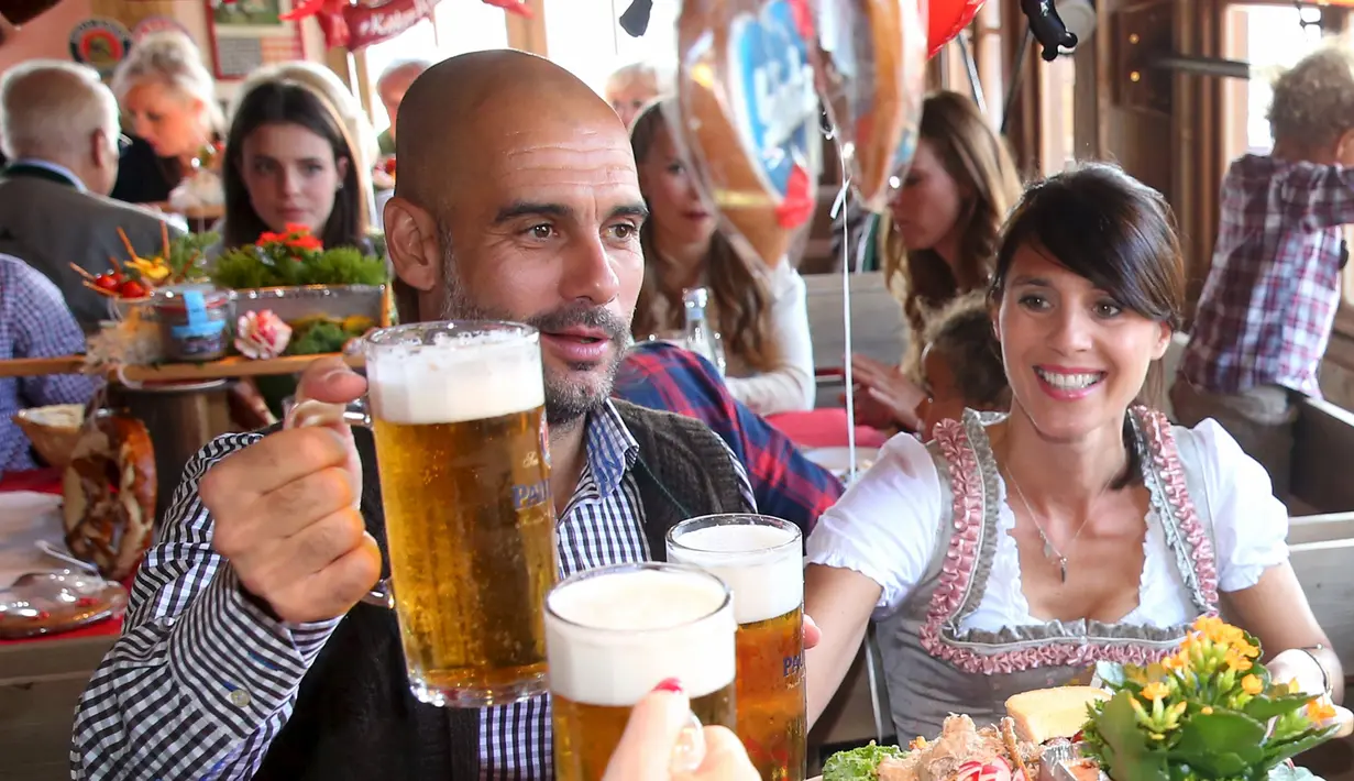 Pelatih tim Bayern Munchen Pep Guardiola bersama istrinya Cristina saat menghadiri Festival Oktoberfest di Munich, Jerman, Rabu (30/9/2015). (REUTERS/Alexander Hassenstein/Pool)
