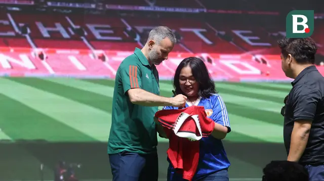 Legenda Manchester United, Ryan Giggs menandatangani jersey yang dibawa seorang fans setia Setan Merah dalam acara Konferensi Pers Maybank Kartu Kredit Manchester United, di Plenary Hall, JCC, Jakarta, Sabtu (18/5/2024). (Bola.com/M Iqbal Ichsan)