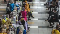 Warga menunggu untuk menerima dosis vaksin virus corona COVID-19 Sinovac di sebuah mal di Surabaya, Jawa Timur, Kamis (23/9/2021). Vaksinasi COVID-19 di Surabaya dilakukan di fasilitas kesehatan, mal, perkantoran, kelurahan hingga balai RW. (Juni Kriswanto/AFP)