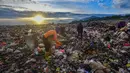 Warga yang berprofesi sebagai pemulung mengumpulkan sampah plastik dengan latar belakang Gunung Gede-Pangrango di Tempat Pembuangan Akhir Galuga, Bogor, Kamis (6/11/2025). Arahan ini bertujuan untuk mencegah pencemaran lingkungan dan penyebaran mikroplastik. (merdeka.com/Arie Basuki)