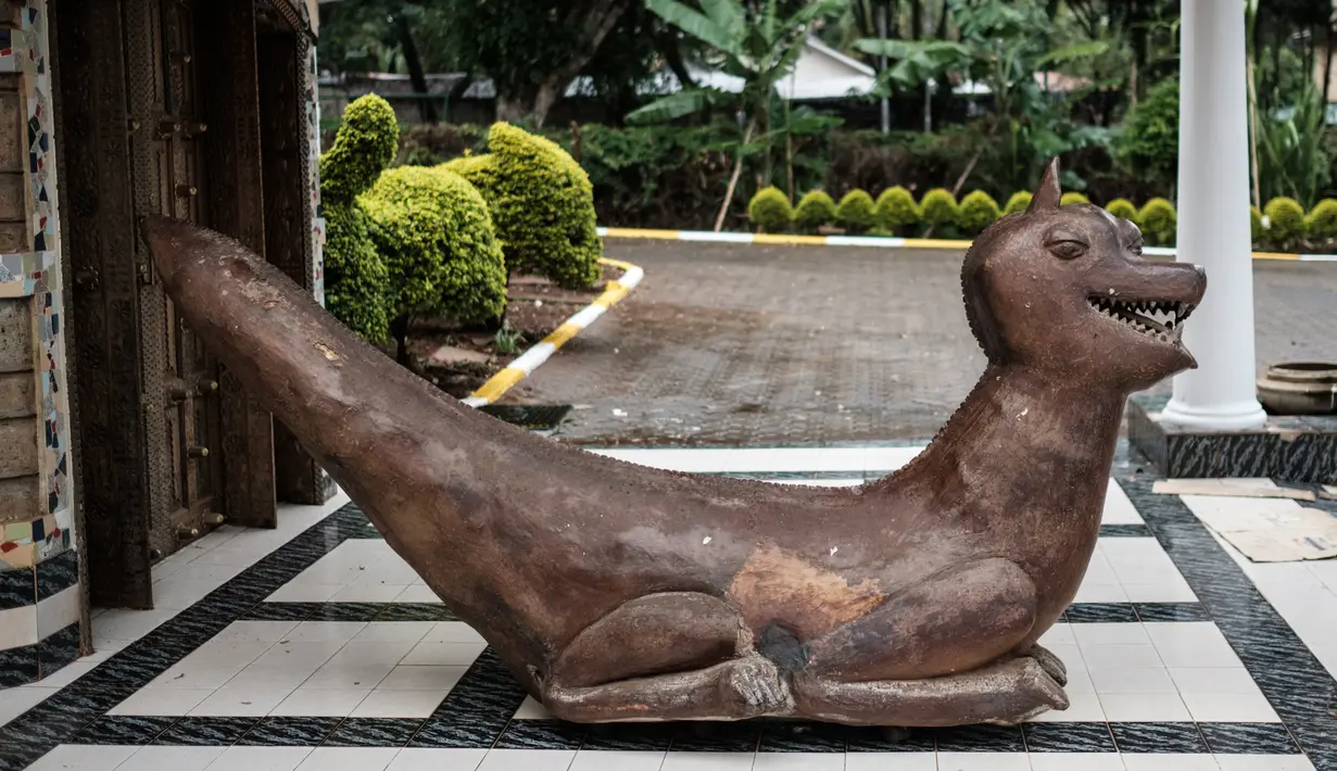 Patung bernama 'Laughing Dragon' yang diciptakan oleh pemahat Edward Njenga terpampang di pintu masuk rumahnya di Nairobi, Kenya, Senin (12/3). (AFP PHOTO/Yasuyoshi CHIBA)