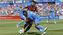 Striker Barcelona, Luis Suarez, berusaha melewati bek Getafe, Dakonam Djene, pada laga La Liga di Stadion Alfonso Perez, Sabtu (16/9/2017). Barcelona menang 2-1 atas Getafe. (AP/Francisco Seco)