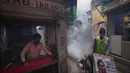 Pekerja kota melakukan fogging atau pengasapan daerah padat penduduk di New Delhi, India, Rabu (27/10/2021). New Delhi telah melaporkan ratusan kasus demam berdarah, dengan lebih dari 200 kasus baru dalam seminggu terakhir, menurut laporan yang dirilis pada hari Senin. (AP Photo/Manish Swarup)