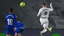 Striker Real Madrid, Karim Benzema (kanan) melepaskan sundulan ke gawang Getafe yang berbuah gol pertama timnya dalam laga lanjutan Liga Spanyol 2020/21 pekan ke-22 di Alfredo di Stefano Stadium, Selasa (9/2/2021). Real Madrid menang 2-0 atas Getafe. (AFP/Gabriel Bouys)